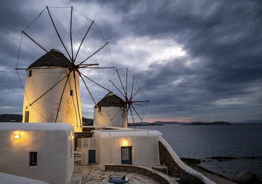 Illuminated windmills, Kato Milli, at sunset, dramatic cloudy sky, Mykonos Town, Mykonos, Greece