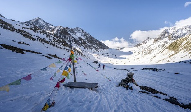 Prayer flags, snow-covered mountain landscape, ski tourers climbing Alpeiner Ferner, Stubai Alps, Tyrol, Austria