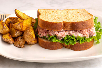 h am salad  sandwich  served  with a side of potato wedges