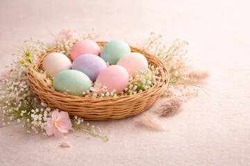 Easter eggs in pastel colors with floral decoration and wicker basket