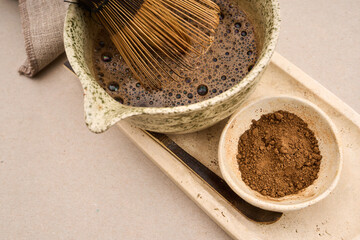 Whisking hojicha roasted green tea in ceramic bowl