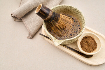 Preparing hojicha tea with bamboo whisk and powder