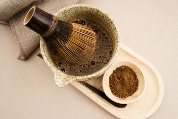 Preparing hojicha tea in ceramic bowl with whisk