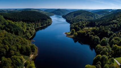 Obraz premium Reservoir surrounded by lush forest, aerial view