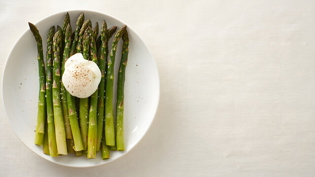Fresh green asparagus spears on a white plate