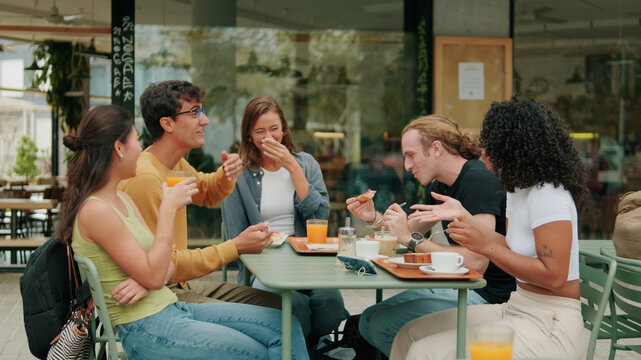 Friends Sharing Meal at Outdoor Caf&eacute; Table