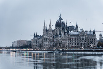 Obraz premium Parliament building in the old historic city of Budapest next to the Danube River, at the morning, covered with snow. Budapest, capital of Hungary.