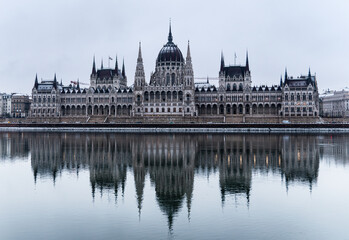 Obraz premium Parliament building in the old historic city of Budapest next to the Danube River, at the morning, covered with snow. Budapest, capital of Hungary.