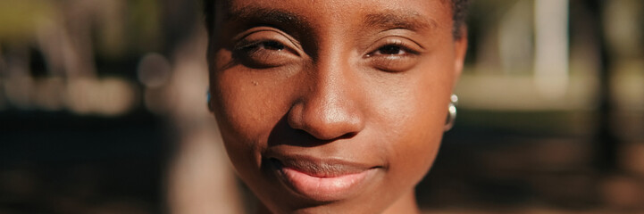 Fototapeta premium Close-up of happy young woman outdoors in the park. Panoramic. Panoramic