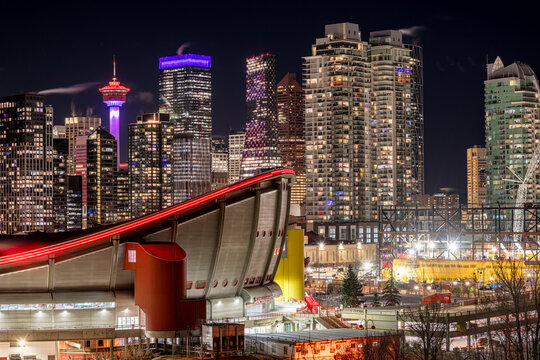 Calgary, Alberta, Canada &ndash; January 18, 2026: Downtown at night, featuring the tower lit in red and the Scotiabank Saddledome in the foreground.