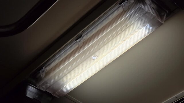 Ceiling light fixture inside a train carriage, close-up.