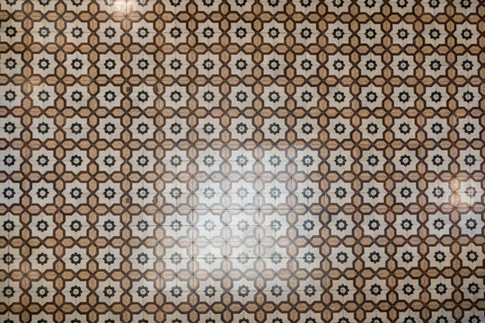 Piso antiguo patr&oacute;n geom&eacute;trico mosaico cer&aacute;mico marr&oacute;n con flores negras