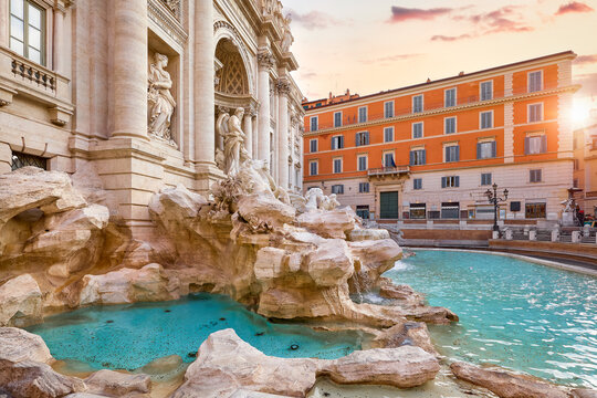 Trevi Fountain in Rome, Italy. Ancient fountain. Roman statues at piazza in old medieval city among traditional italian houses and street lamps. Famous landmark. Touristic destination for vacation..