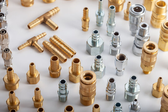 Large collection of brass and steel pneumatic fittings including hose barbs and quick couplers, professional industrial hardware assortment for fluid engineering and workshop maintenance systems