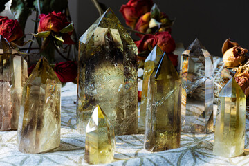 Several tall citrine crystal towers lined up on a crystal grid cloth with sacred geometry.
