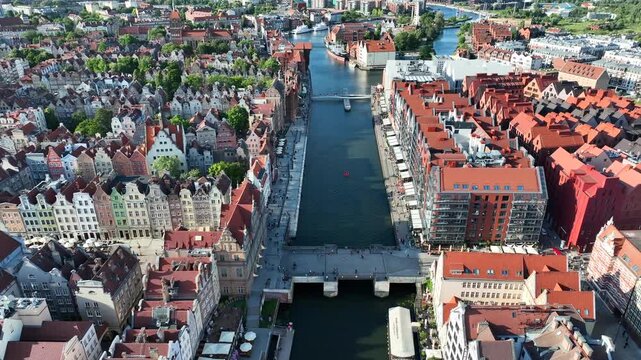 Aerial flyover video of Gdansk Old Town with Motlawa River, colorful historic townhouses and waterfront cityscape, Poland