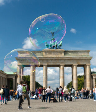 Germany, Berlin.   Large soap bubbles floating above the Brandenberg Gate. 