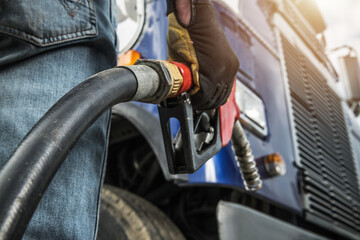 Worker Fills Truck With Fuel at a Gas Station
