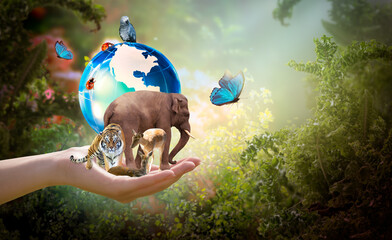 Earth Day or World Wildlife day concept. Group of animals, butterflies and globe in hand. Saving planet, protect wildlife nature reserve, protection of endangered species and biological diversity.