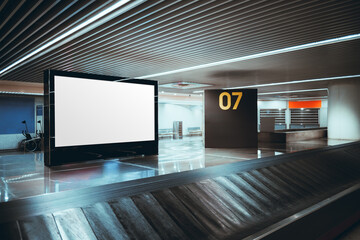 Empty horizontal billboard mockup beside airport baggage claim conveyor, modern terminal interior...