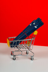 Shopping cart with insulin pen, syringes on red, orange background