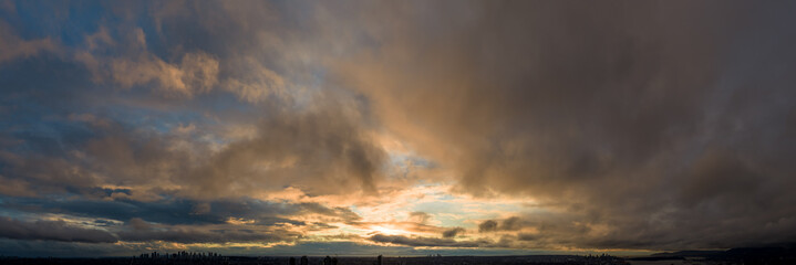 Dramatic Sunset Over Cloudy Sky With City Silhouette at Dusk in BC Canada © edb3_16