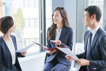 紙資料を持って会議するビジネスパーソン