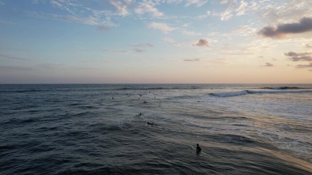 people surfing at El Sunzal beach, at sunset, El Salvador