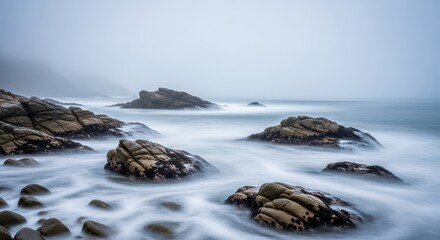 Fototapeta premium Dense, mysterious fog shrouds the calm ocean waves and coastal rocks, defining a tranquil, isolated morning seascape, morning, damp, ocean