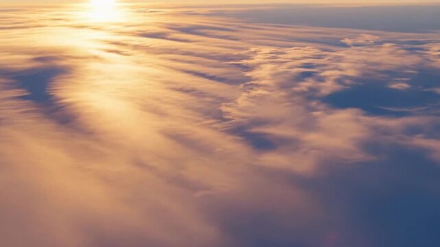 Golden sunrise above soft cloud deck, aerial horizon view for travel and aviation backgrounds, calm dreamy atmosphere, winter solstice morning light