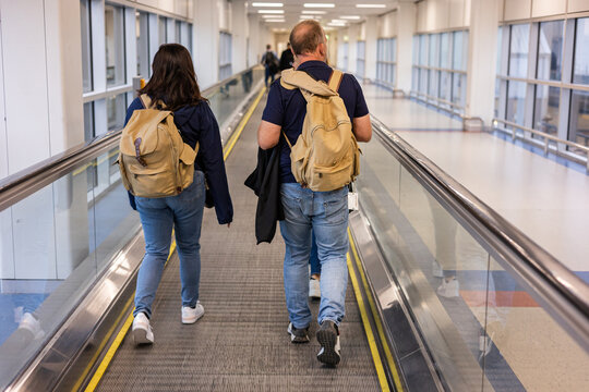 three travelers on the conveyor belt at an airport