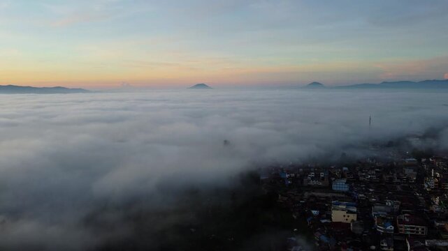 Sea of Fog Over Berastagi with Silhouetted Mountain and Sunlight