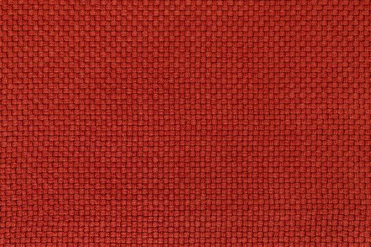 Detailed texture of brick red woven fabric background. Top view of warm textile material with a basket weave pattern