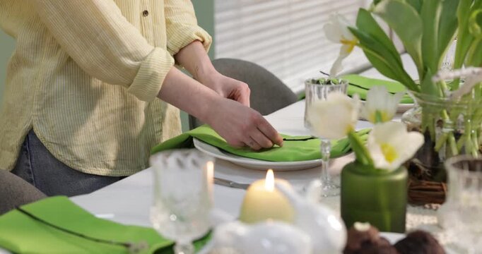 Woman setting festive table for Easter celebration at home, closeup