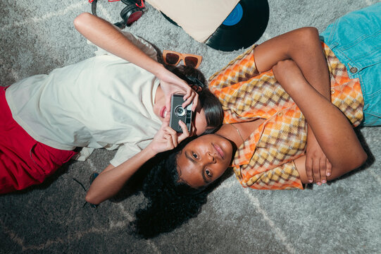 Diverse friends capturing memories with vintage camera and music