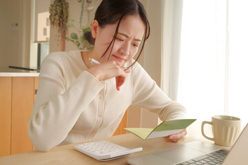通帳をみてお金の管理をする女性