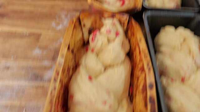 Baker places a braided praline-filled dough by hand into a metal mold