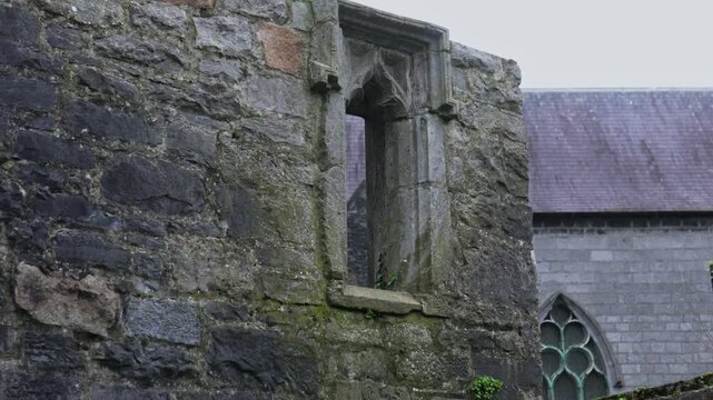 A detailed close up of the weathered limestone window and wall of the Lynch Memorial Window in Galway a 15th century Gothic monument, Ireland
