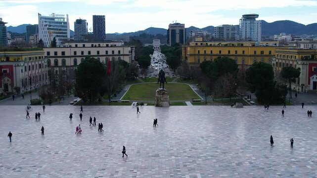 Cinematic view of Skanderbeg sculpture national hero in Tirana main square with busy city traffic