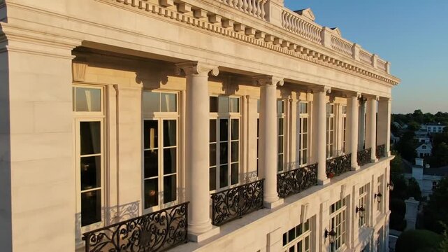 Elegant Classical Building Facade with Balconies and Windows in Golden Hour Sunlight