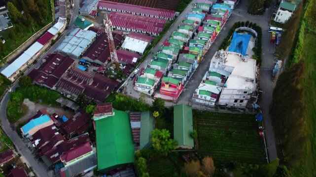 Aerial view of Berastagi town shrouded in thick morning mist and fog with mountain landscape, North Sumatra, Indonesia