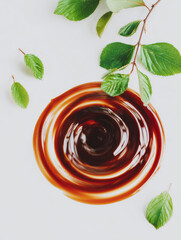 Organic compost tea liquid swirl with fresh green leaves on white background creating natural and healthy concept for gardening and plant care