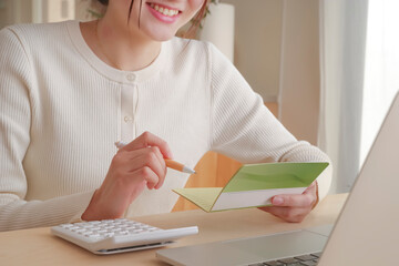 通帳をみてお金の管理をする女性