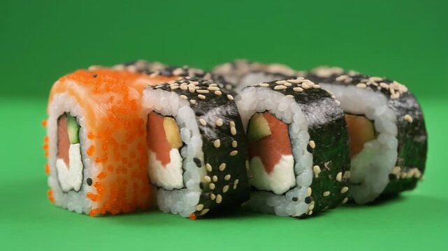 Fresh Philadelphia Sushi Rolls with Salmon and Tobiko on Green Background
