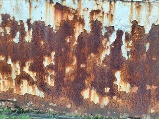 Close-up of heavily rusted metal with peeling white paint