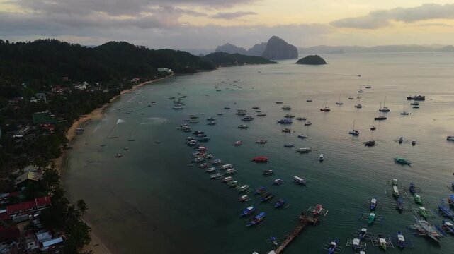 drone shot focusing on the high concentration of outrigger boats and vessels in El Nido bay, Philippines.