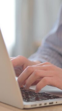 Close Up of Young Woman Typing on Laptop, vertical video