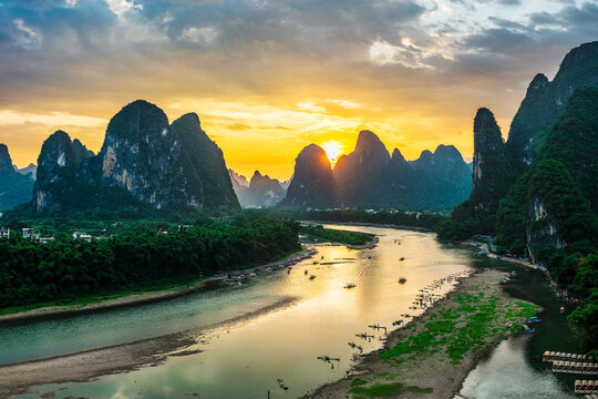 Beautiful aerial view of the winding Li River and karst mountains during a golden sunset in Guilin, China.