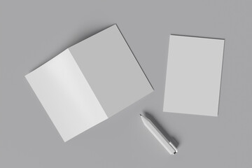 blank bi-fold brochure on grey background with pen