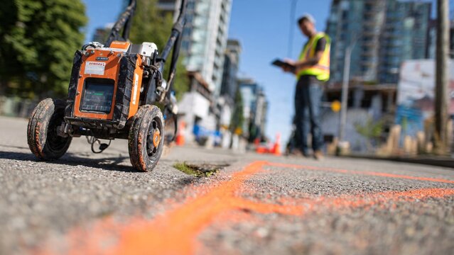Surveyor Using Ground Penetrating Radar Cart on Site | Subsurface Mapping & Construction Background | Urban Development Stock Photo